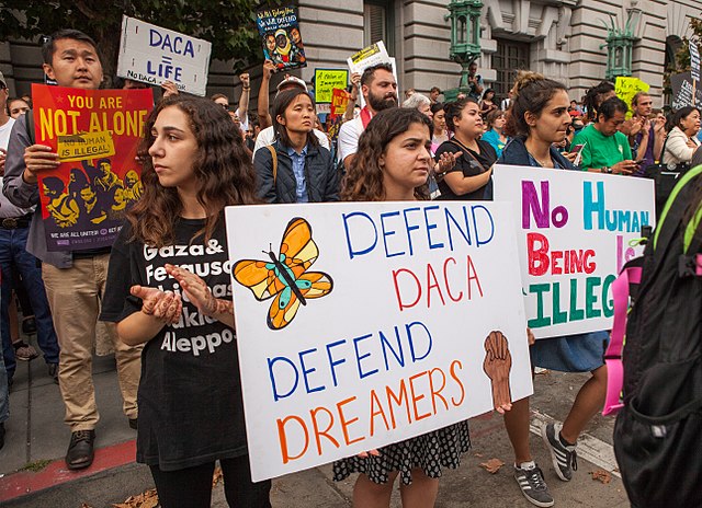 Picture of protesters holding sign that reads "Defend DACA, Defend Dreamers"